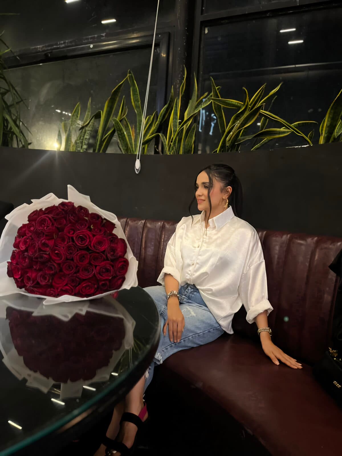زهرا نشسته کنار دسته‌گل بزرگ رز سرخ